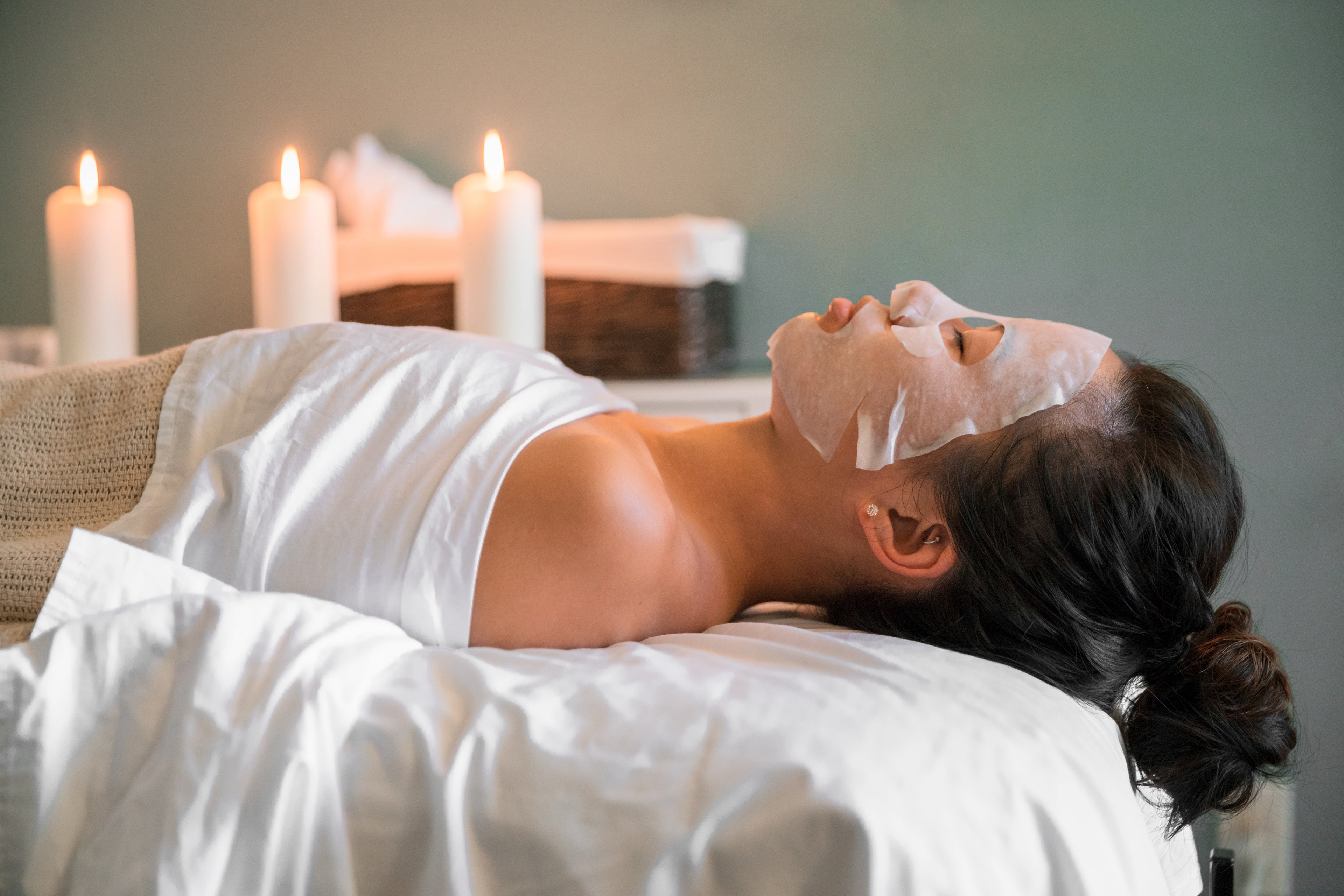 woman getting korean facial with sheet mask